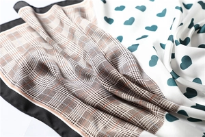 Detail of satin silk scarf featuring heart patterns and houndstooth print texture