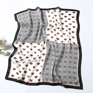 Detail of checkered and heart pattern silk scarf with elegant black border trim