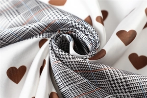 Macro detail of houndstooth silk scarf with heart prints and smooth texture