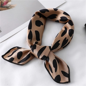 Foulard in seta leopardato champagne annodato a fiocco su sfondo bianco pulito