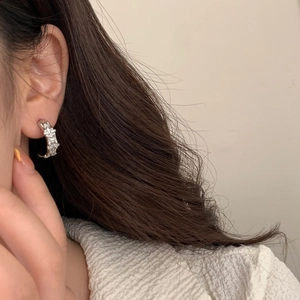 Sparkling zircon-inlaid silver C-shaped bamboo stud earrings worn by a model