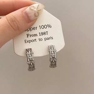 Detailed macro view of silver-plated copper bamboo earrings with micro-set zircon stones