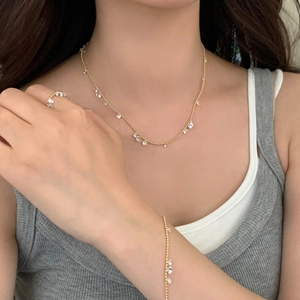 Gold jewelry set featuring sparkling teardrop zircon necklace, bracelet and ring on a model