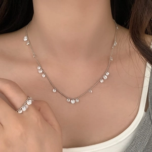 Close-up of sparkling zircon necklace and ring set with clear water drop pendants