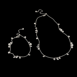 Sparkling zircon water drop necklace and bracelet jewelry set on black background