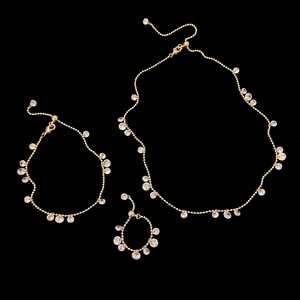 Detail of elegant gold bead chain jewelry set with clear faceted round pendants