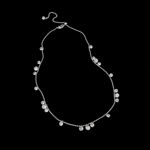 Detail of silver bead chain necklace with shimmering round zircon pendants and lobster clasp