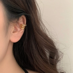 Three-layer gold-plated ear cuff with pavé-set zircons shown on a model's ear