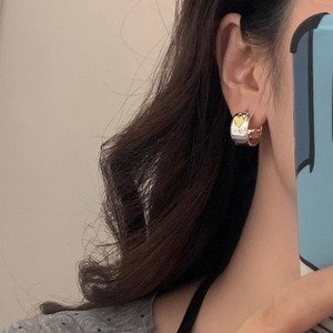 Vintage silver hammered hoop earrings with golden heart detail shown on ear