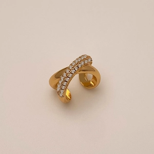 Détail d'un ear cuff croisé doré orné de micro-pavés de zircons brillants et élégants