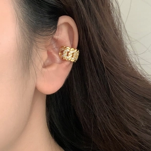 Ear cuff dorato a catena cubana con zirconi brillanti indossato su un modello