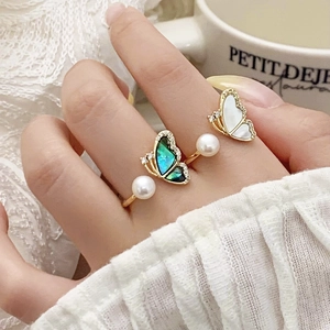 Adjustable gold butterfly ring featuring freshwater pearls and shell wings with micro diamonds
