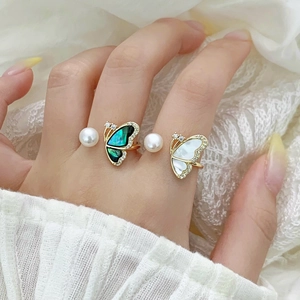 Detail of adjustable butterfly pearl rings with mother-of-pearl inlay and sparkling crystals