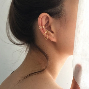 Detail shot of gold hollow star ear cuff and long chain earring set on female model