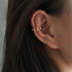 Detail of gold hollow ear cuff with star-shaped zircon inlays on model ear