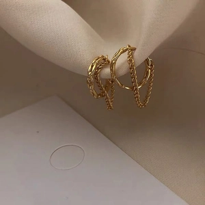 Minimalist gold-plated hollow chain ear cuff with zircon accents on soft silk background