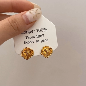 Detailed close-up of vintage French golden camellia stud earrings crafted in 100% copper