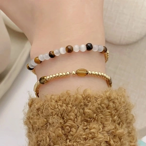 Tiger eye stone beaded bracelet set with gold accents for a retro layered aesthetic