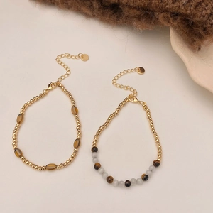 Detailed macro of vintage tiger eye and cat eye beaded bracelets with gold finish
