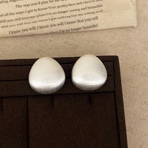 Minimalistische matt silberne Tropfenohrstecker mit gebürstetem Metall-Finish auf Samt