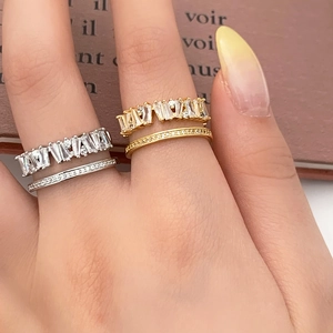 Detail of stacked gold and silver rings with rectangular crystals on a finger