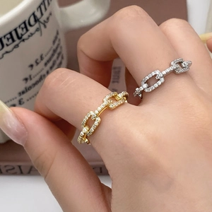 Macro shot of gold and silver chain link rings with paved cubic zirconia stones