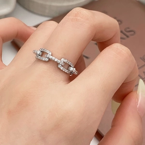 Elegant silver-toned chain link ring with pavé-set stones worn on model's finger