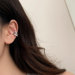 Close-up of silver multilayer ear cuff with pavé zircon and link detail on a model's ear