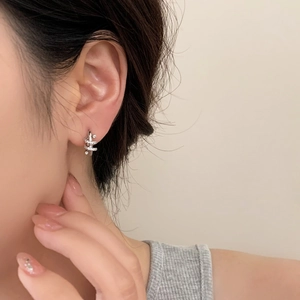 Elegant silver spiral hoop earrings with micro-inlaid cubic zirconia on female model