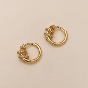 Close-up of gold-plated hoop earrings with micro-set cubic zirconia and a woven design