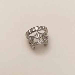 Macro shot of silver ear cuff with multilayer hollow design and zircon inlay detail