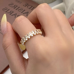 Vue détaillée d'une bague en zircons ovales dorés portée délicatement au doigt