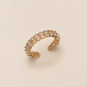 Vue macro d'une bague dorée ajustable sertie de treize zircons ovales transparents