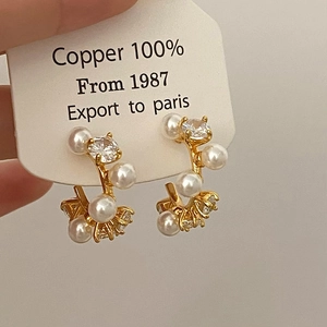 Detailed close-up of gold-plated hoop earrings with white pearls and sparkling zircons