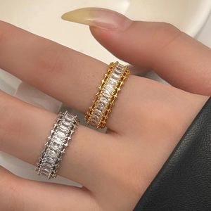 Detail of stacked gold and silver baguette zircon rings on model's fingers