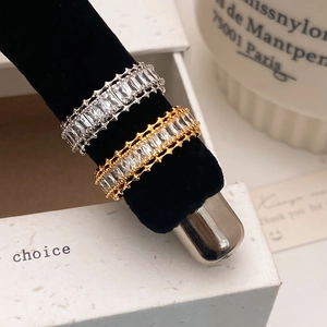 Elegant baguette cut zircon eternity ring in gold and silver finish on velvet display