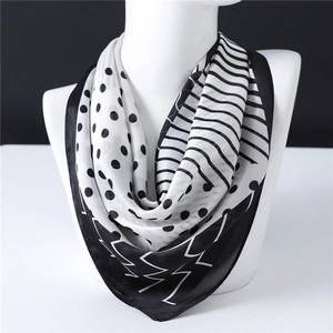 Elegant black and white polka dot silk scarf with stripes on a white mannequin