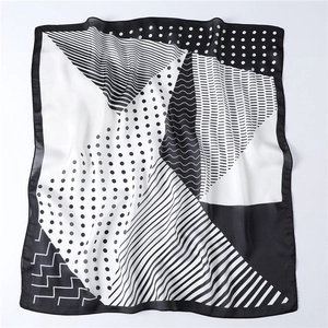 Detail of geometric scarf featuring black and white polka dots, stripes and wave patterns