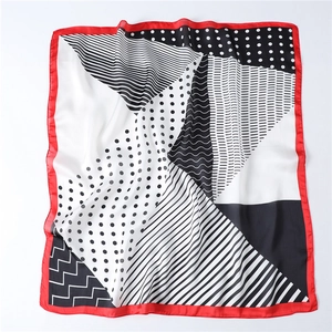 Detail of polka dot and geometric stripe pattern on silk square scarf with red hem