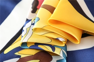 Macro shot of silk texture square scarf with bold geometric print and fine hem details