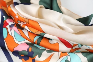 Detailed view of colorful printed silk square scarf with geometric and floral patterns