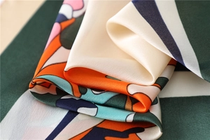 Close-up of geometric silk square scarf with vibrant prints and smooth satin texture
