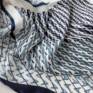 Close-up of elegant silk square scarf with blue and white letter pattern print