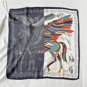 Detailed flat lay of silk square scarf featuring mechanical pegasus art and vibrant wings