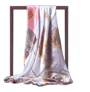 Detail of pink and gold chain print satin scarf with elegant baroque patterns and silky luster