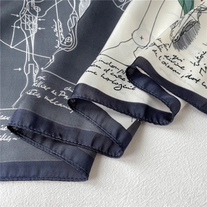 Detail shot of 70cm silk scarf featuring retro technical drawings and rolled hem edges