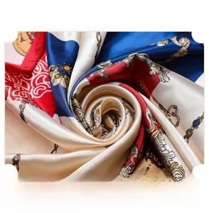 Macro detail of silk satin square scarf featuring luxury chain and emblem print pattern