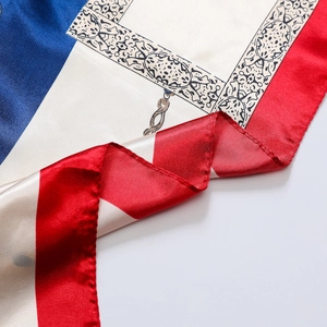 Close-up of silk satin scarf showing chain patterns and smooth red blue color block texture