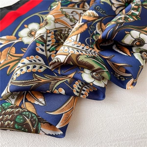 Detailed macro shot of vintage floral satin scarf with polished silk texture and hem