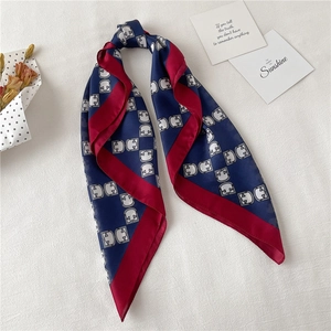 Detail of silk-like navy square scarf with burgundy border and geometric prints